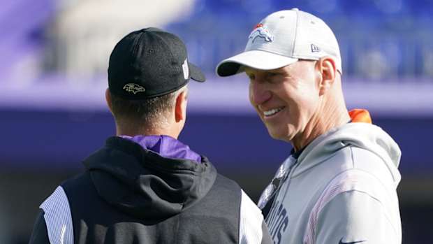 Baltimore Ravens head coach John Harbaugh (left) talks with Denver Broncos coach Jerry Rosburg (right) prior to the game at M&T Bank Stadium.